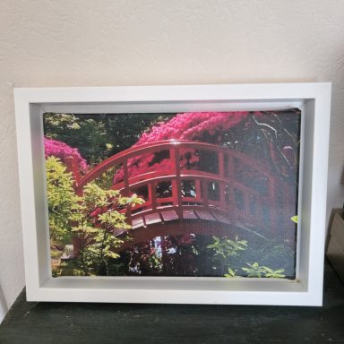 Een brug omringd door bloemen in een groene tuin.